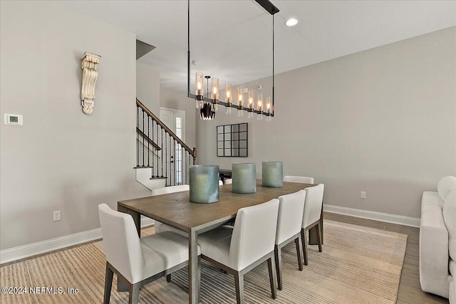 dining space featuring light wood-type flooring and a notable chandelier