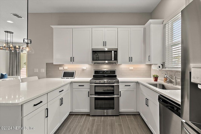 kitchen with white cabinetry, sink, stainless steel appliances, and light hardwood / wood-style flooring