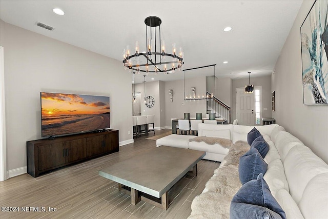 living room with light wood-type flooring and an inviting chandelier