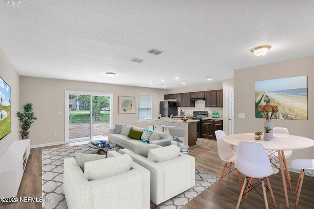 living room featuring a textured ceiling and light wood-type flooring