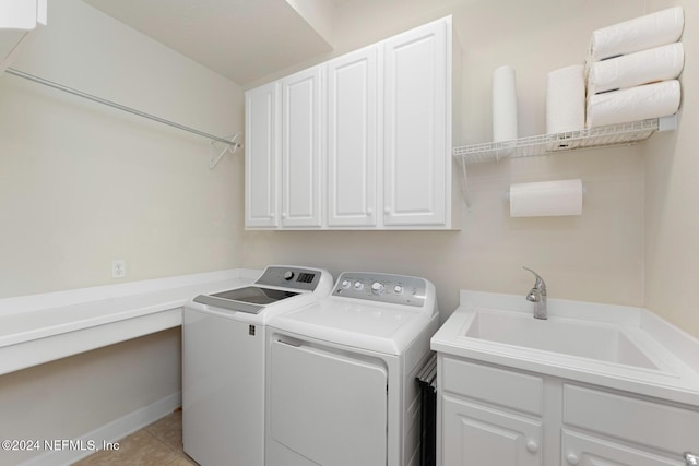 clothes washing area with light tile patterned flooring, cabinets, sink, and washing machine and dryer