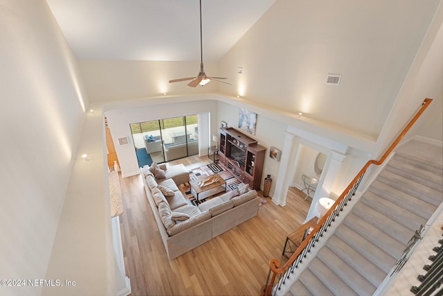 living room with a fireplace, hardwood / wood-style floors, high vaulted ceiling, and ceiling fan