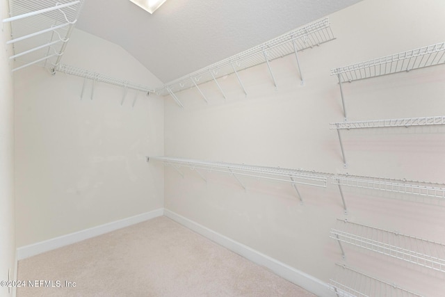 spacious closet with carpet flooring and lofted ceiling