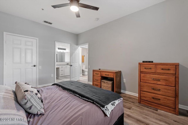 bedroom with connected bathroom, ceiling fan, and light wood-type flooring