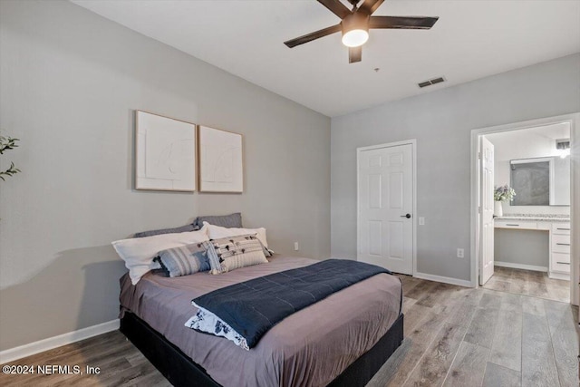 bedroom featuring hardwood / wood-style floors, ceiling fan, and ensuite bath