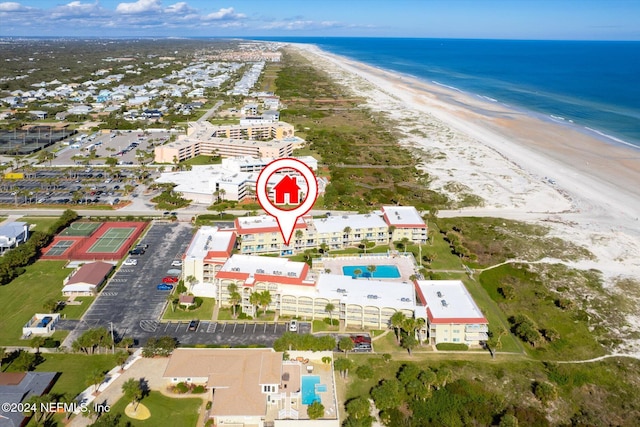 birds eye view of property with a water view and a beach view