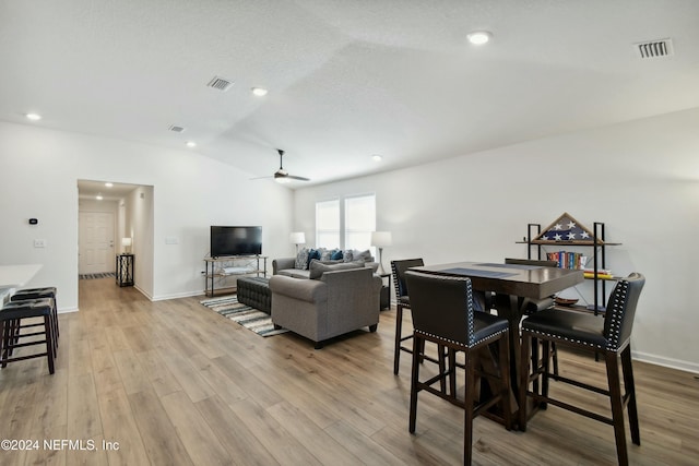 dining space featuring ceiling fan, light hardwood / wood-style floors, and lofted ceiling