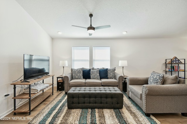 living room with a textured ceiling, hardwood / wood-style flooring, and ceiling fan