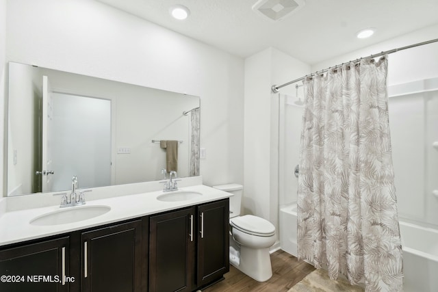 full bathroom with hardwood / wood-style floors, vanity, toilet, and shower / bath combo