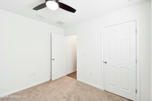 unfurnished bedroom with light colored carpet and ceiling fan