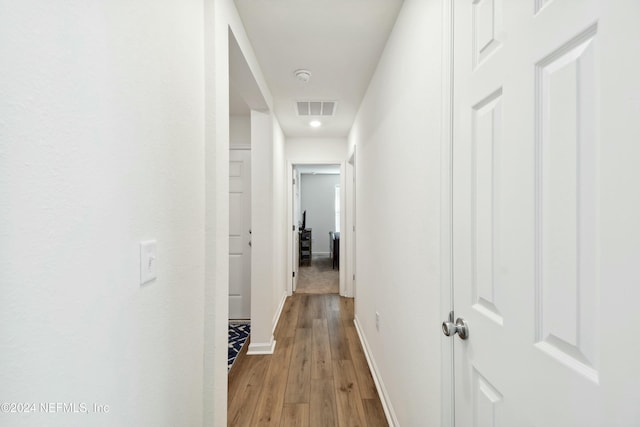 corridor with light hardwood / wood-style floors