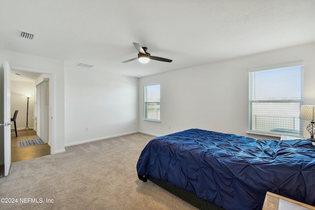 bedroom with ceiling fan and light colored carpet