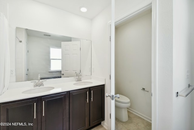 bathroom with tile patterned flooring, vanity, and toilet