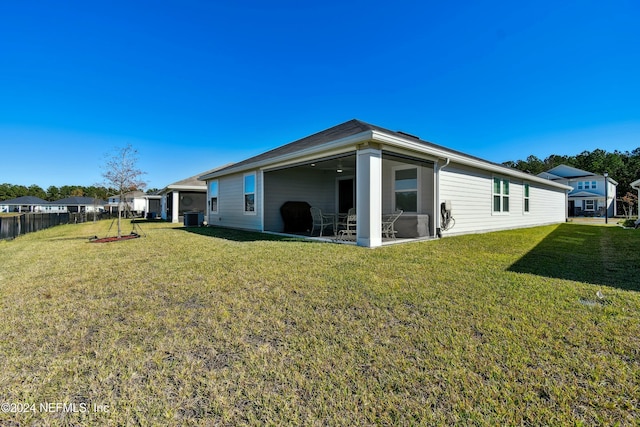 back of property featuring central AC unit and a yard