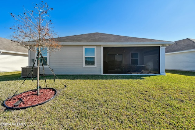 back of property with a yard, central air condition unit, and a sunroom