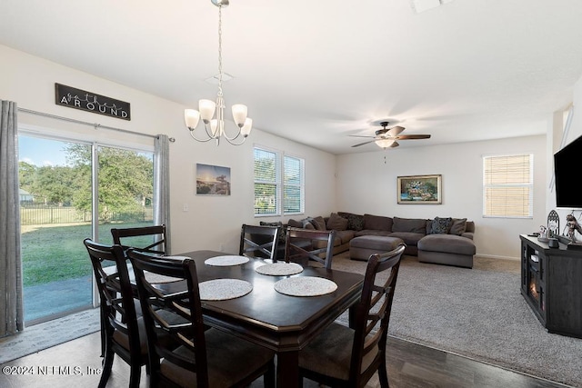 dining space featuring dark hardwood / wood-style flooring, a healthy amount of sunlight, and ceiling fan with notable chandelier