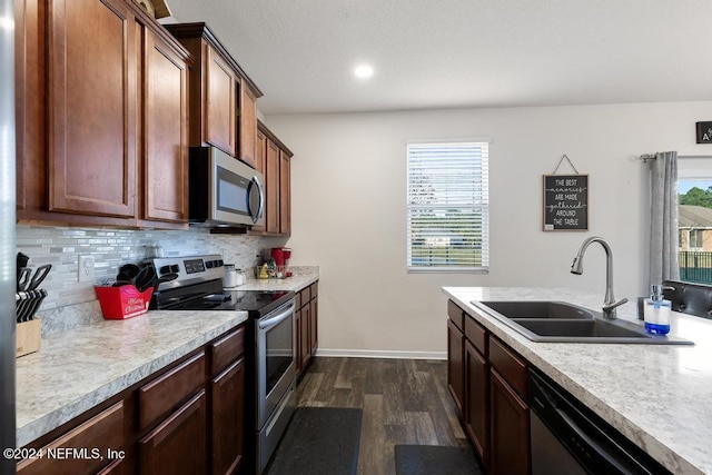 kitchen featuring appliances with stainless steel finishes, dark hardwood / wood-style flooring, a wealth of natural light, and sink