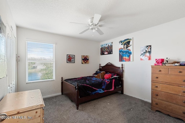 bedroom featuring dark colored carpet, ceiling fan, and a textured ceiling