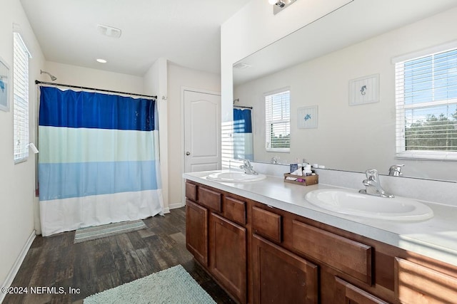 bathroom with shower / bathtub combination with curtain, a wealth of natural light, hardwood / wood-style floors, and vanity