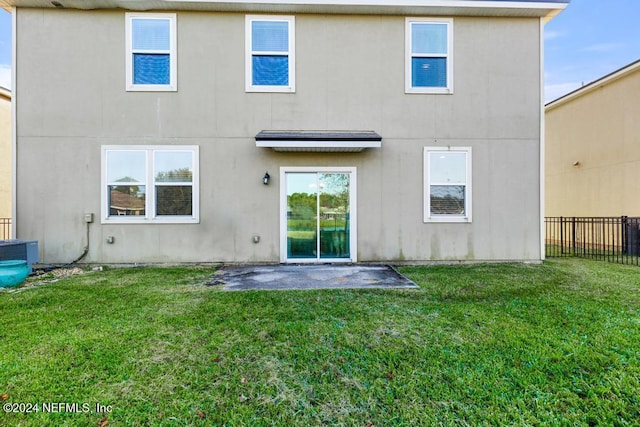 rear view of house with a patio area, a yard, and central AC