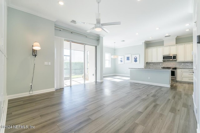 unfurnished living room with light hardwood / wood-style floors, ceiling fan, ornamental molding, and sink