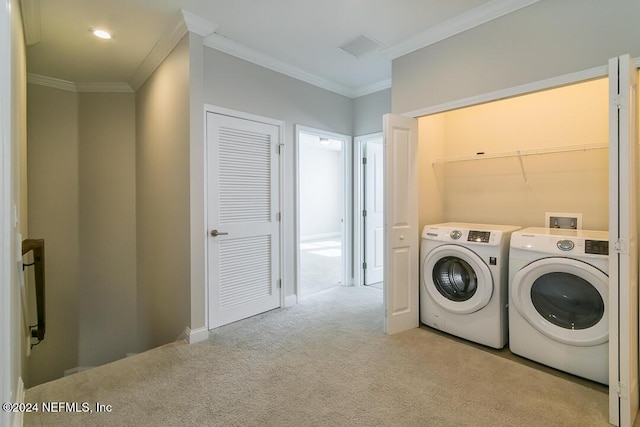 washroom with washer and clothes dryer, light colored carpet, and ornamental molding