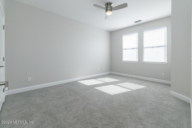 empty room featuring ceiling fan and light colored carpet