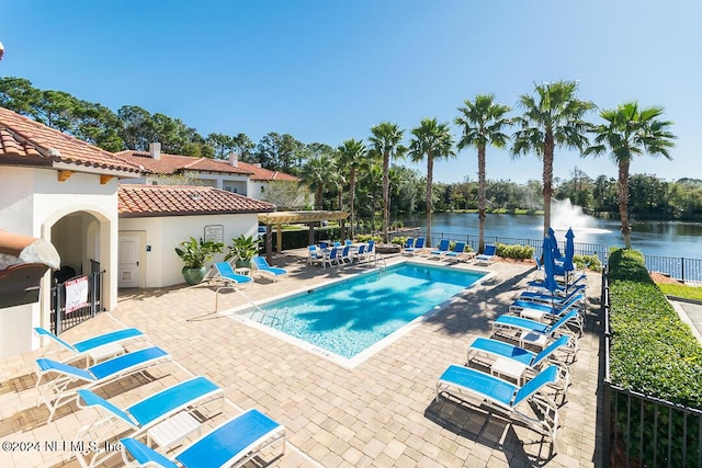 view of swimming pool with a patio area and a water view