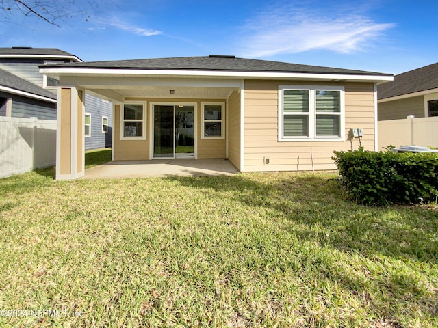 back of property with a yard and a patio