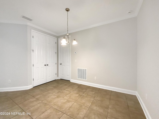 tiled spare room with a chandelier and ornamental molding