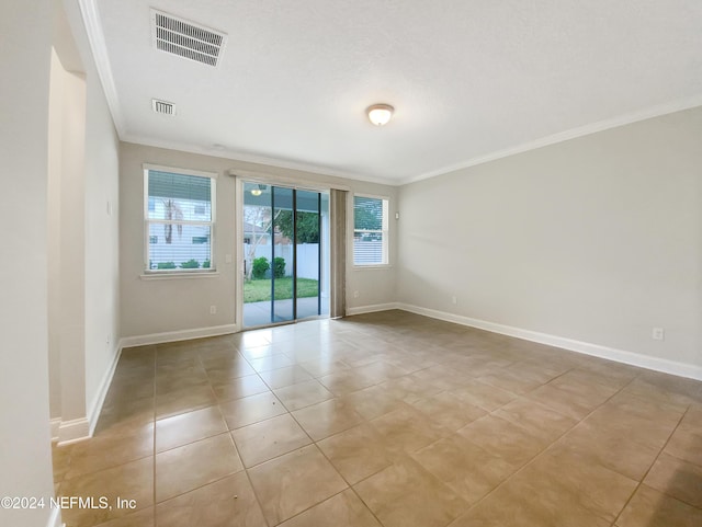 empty room featuring light tile patterned floors and crown molding