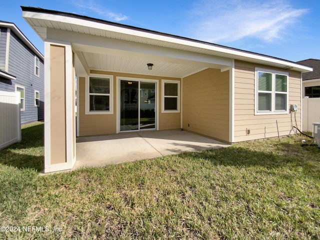 rear view of property featuring a lawn and a patio