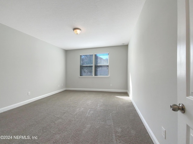 carpeted spare room featuring a textured ceiling