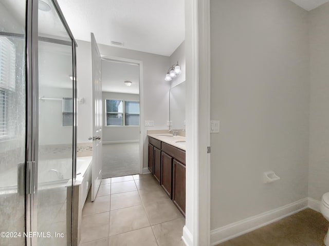 bathroom featuring toilet, vanity, tile patterned floors, and an enclosed shower