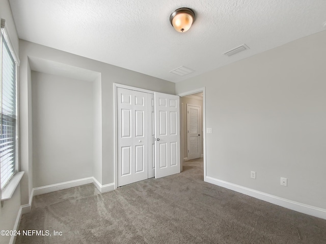 unfurnished bedroom with carpet, a closet, and multiple windows