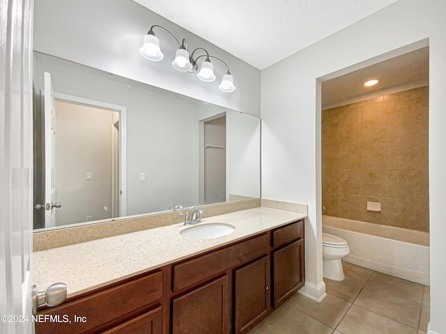 full bathroom featuring vanity, tile patterned floors, tiled shower / bath combo, toilet, and a textured ceiling