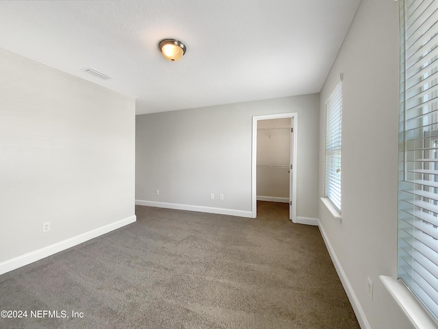 spare room with dark colored carpet