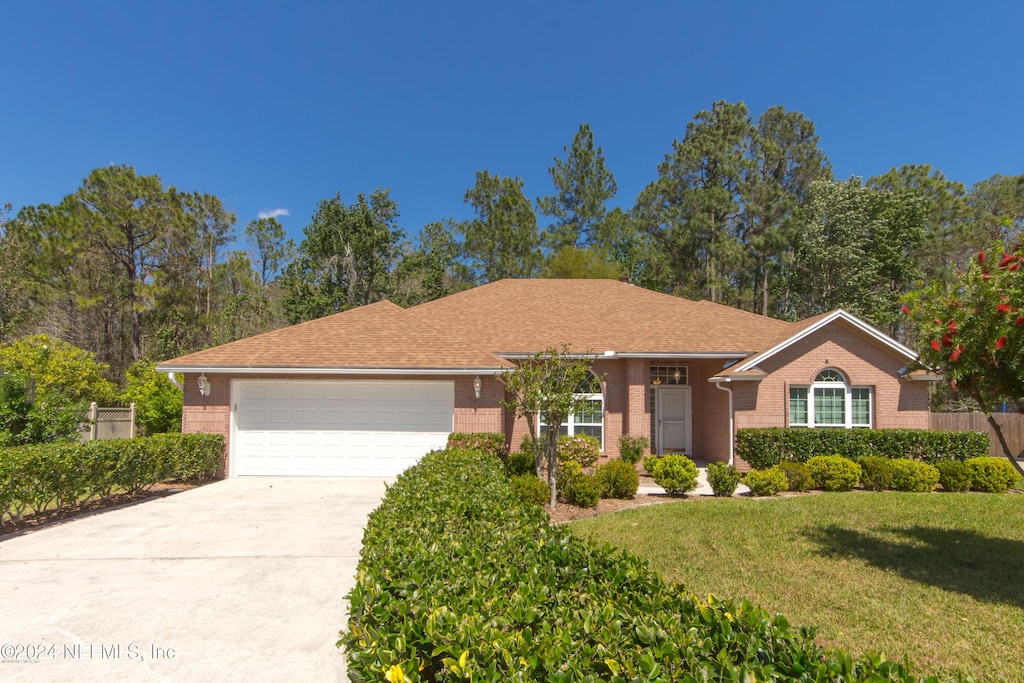 single story home featuring a front yard and a garage