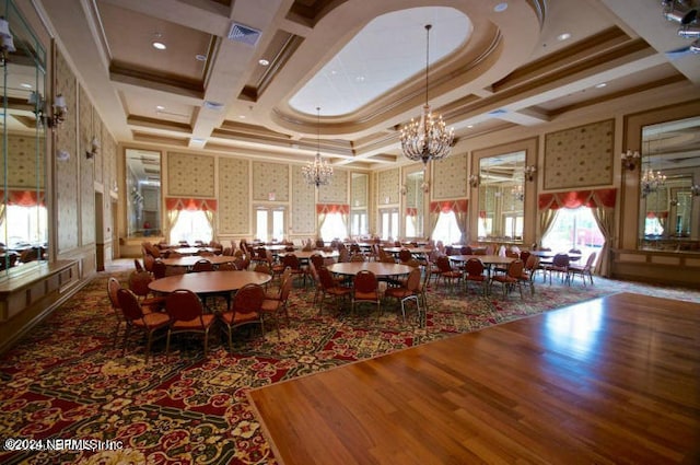 dining area featuring crown molding, a towering ceiling, coffered ceiling, and a notable chandelier