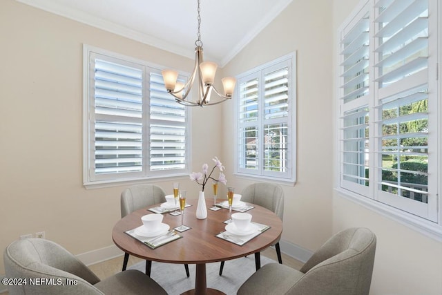 dining space featuring a chandelier, lofted ceiling, and ornamental molding