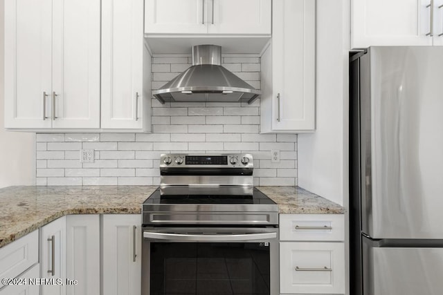 kitchen featuring white cabinets, light stone countertops, wall chimney range hood, and stainless steel appliances