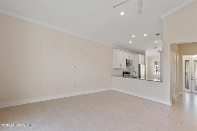 unfurnished living room with ceiling fan, sink, and crown molding