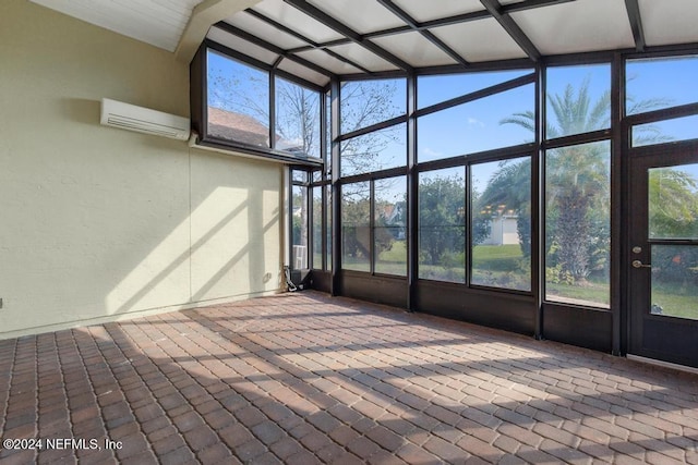 unfurnished sunroom featuring vaulted ceiling with beams, a healthy amount of sunlight, and a wall mounted AC