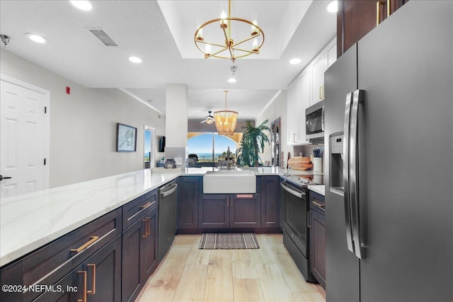 kitchen with pendant lighting, sink, appliances with stainless steel finishes, and a chandelier