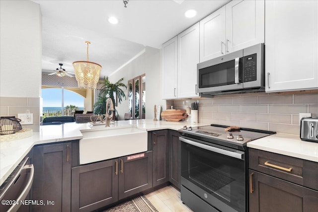 kitchen with appliances with stainless steel finishes, white cabinetry, pendant lighting, and sink