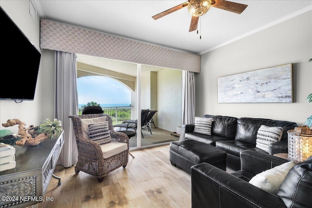 living room featuring ceiling fan, ornamental molding, and light wood-type flooring