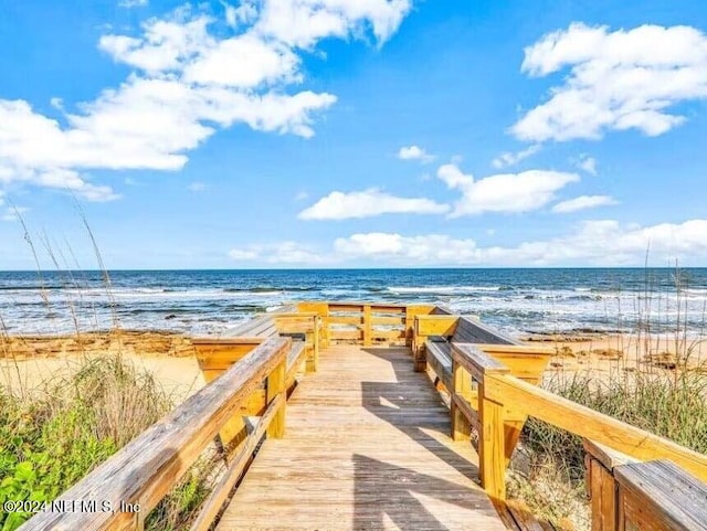 view of property's community featuring a beach view and a water view