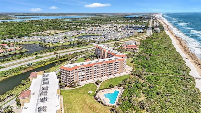 birds eye view of property with a water view and a beach view