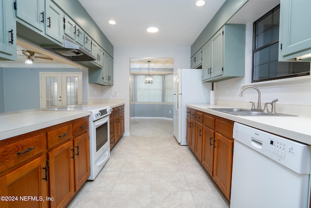 kitchen featuring french doors, sink, pendant lighting, white appliances, and ceiling fan with notable chandelier