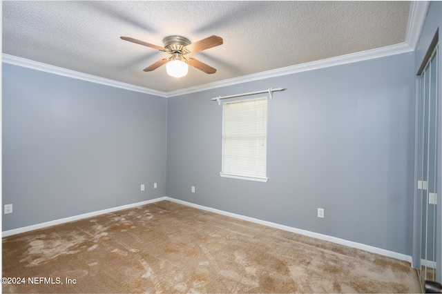 empty room with crown molding, ceiling fan, light carpet, and a textured ceiling